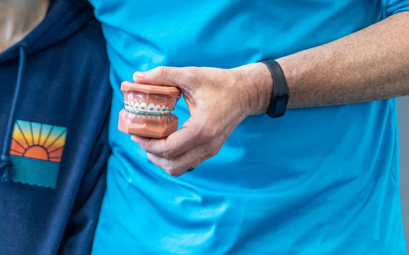 A close view of braces with colored elastic bands
