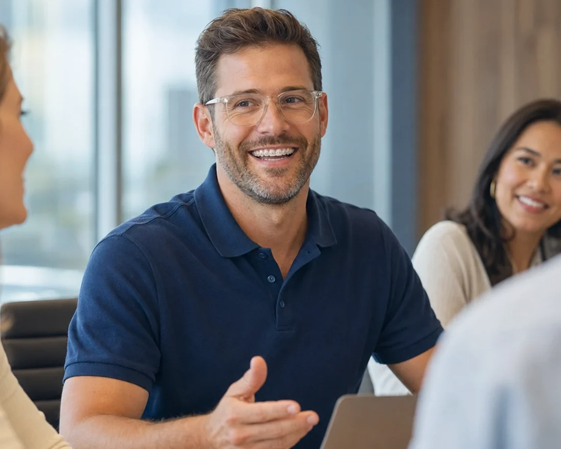 An adult man with clear braces talking with colleagues at work